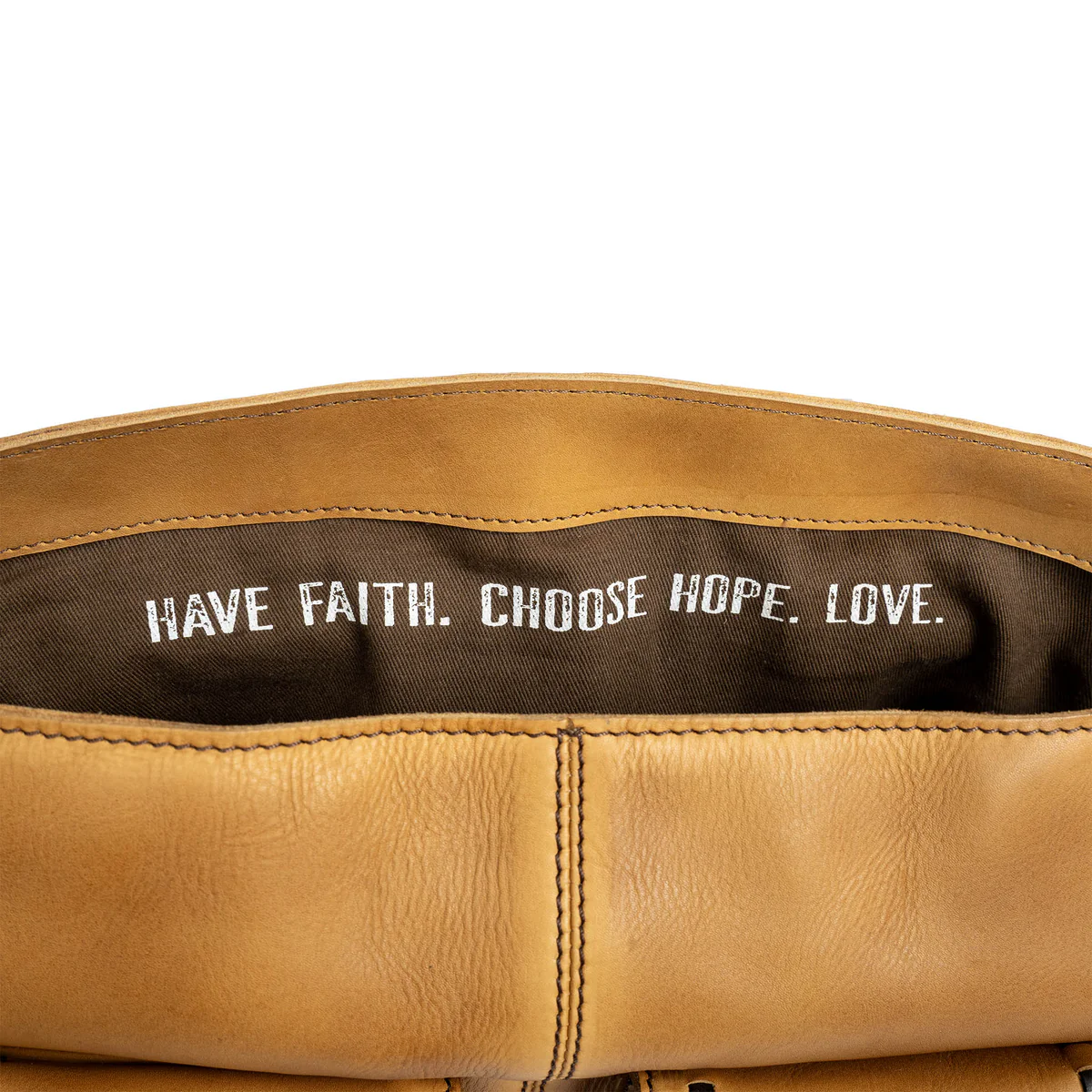Brown leather bag with motivational text inside on a white background