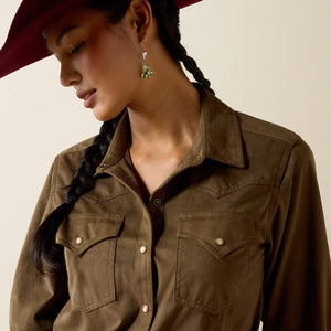 A woman modeling aolive green long-sleeve button-up shirt with two chest pockets. 