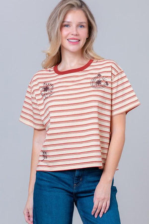 Woman wearing a striped t-shirt with small graphic designs 