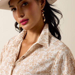 Woman wearing a patterned shirt with a neutral background