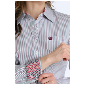 Close-up of a person wearing a striped shirt with patterned cuffs.