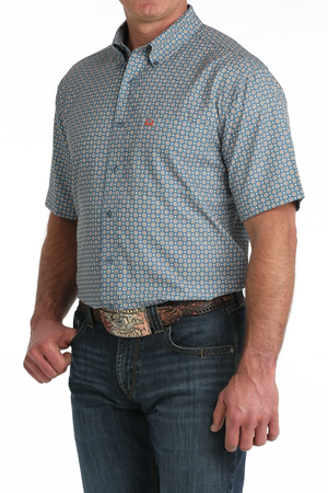 Man wearing a patterned short-sleeve shirt and jeans on a white background