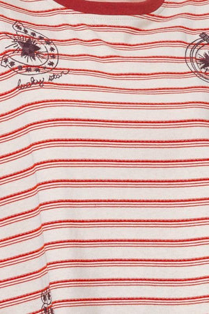 Woman wearing a striped t-shirt with small graphic designs 