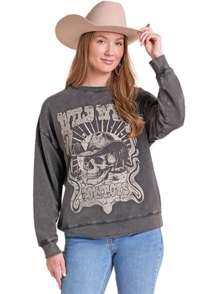 A woman wearing a dark gray acid-wash graphic sweatshirt with a skull and 'Wild West Cowboys' print, paired with blue jeans and a beige cowboy hat, against a plain white background.