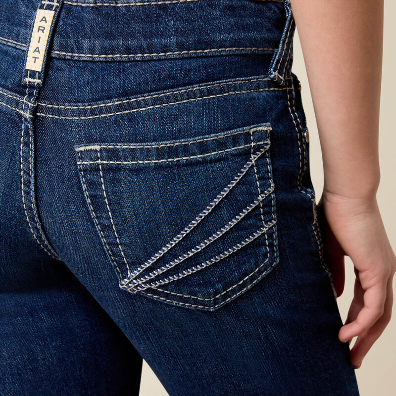 Close-up of the back of dark blue denim jeans with white contrast stitching, showing the pocket detail and a vertical brand tab reading ARIAT.