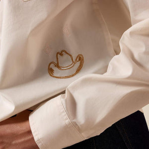 Close-up of a beige garment with an embroidered design on a blurred background