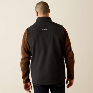 Man wearing a black Ariat Vest on a beige background