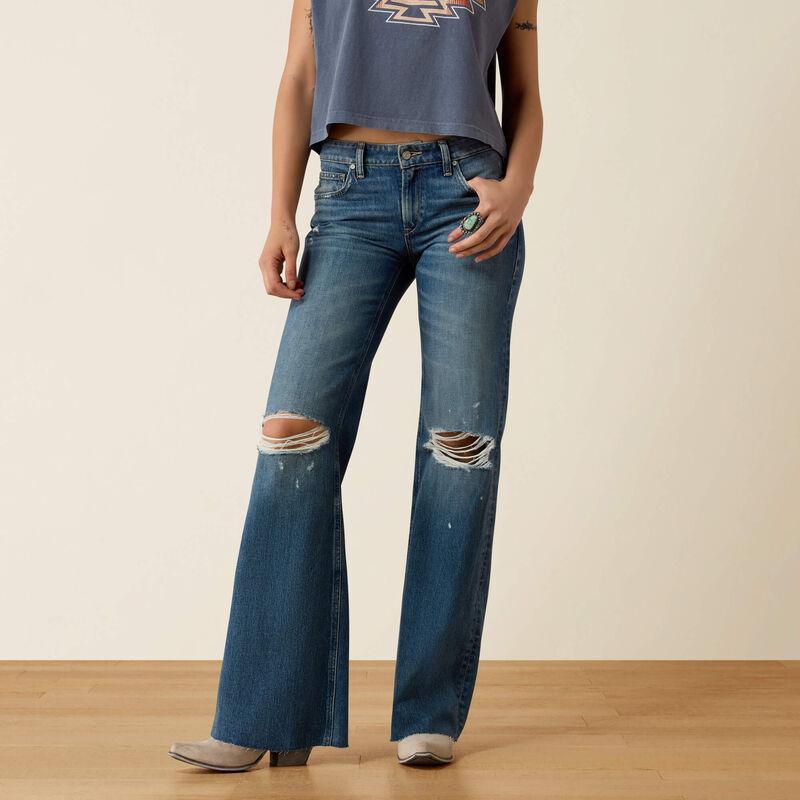 A model wearing blue distressed flare jeans with ripped knees