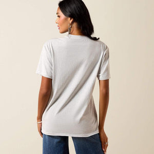 Woman wearing a plain white t-shirt and blue jeans against a beige background