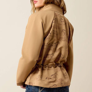 A woman wearing a tan western-style zip-front jacket with a brown horse-print pattern. 